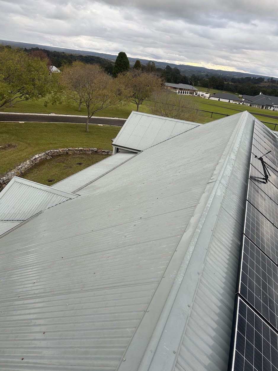 Clean Colorbond metal roof with solar panels after soft washing